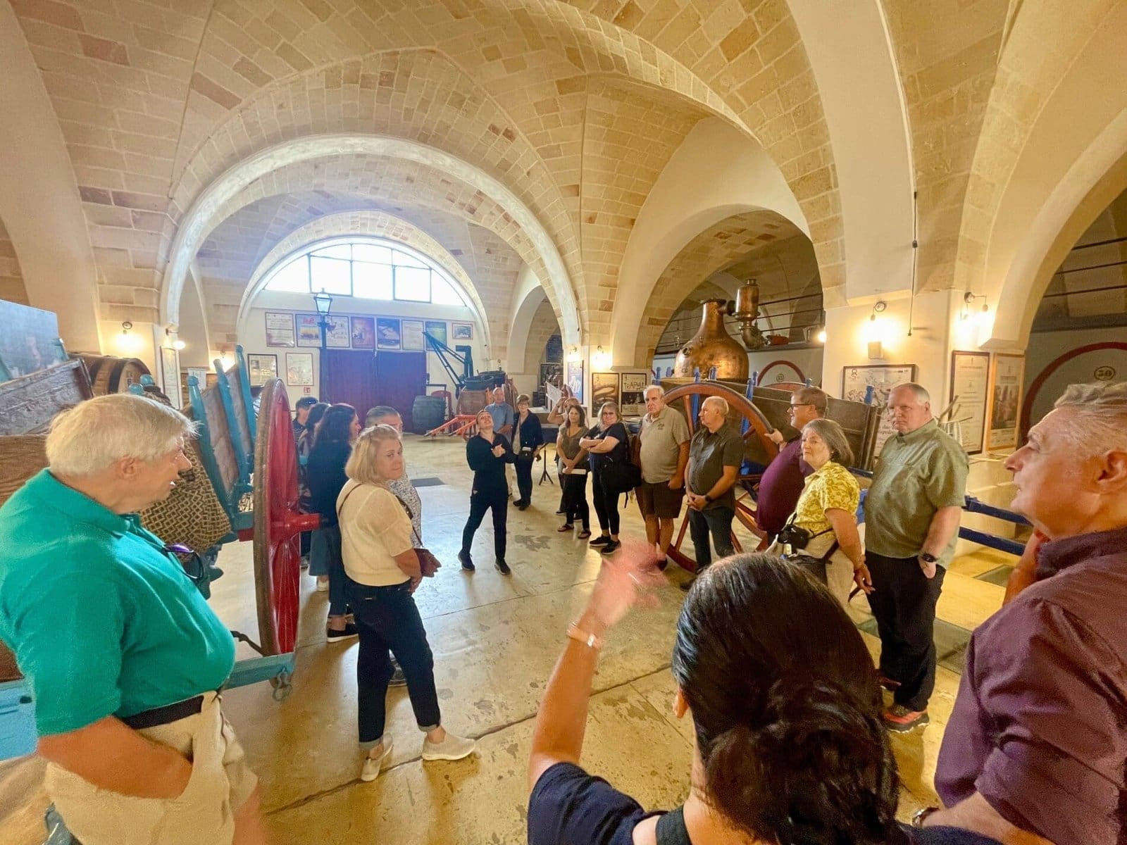Visitors on a guided tour inside the historic vaulted hall at Produttori di Manduria in Apulia.
