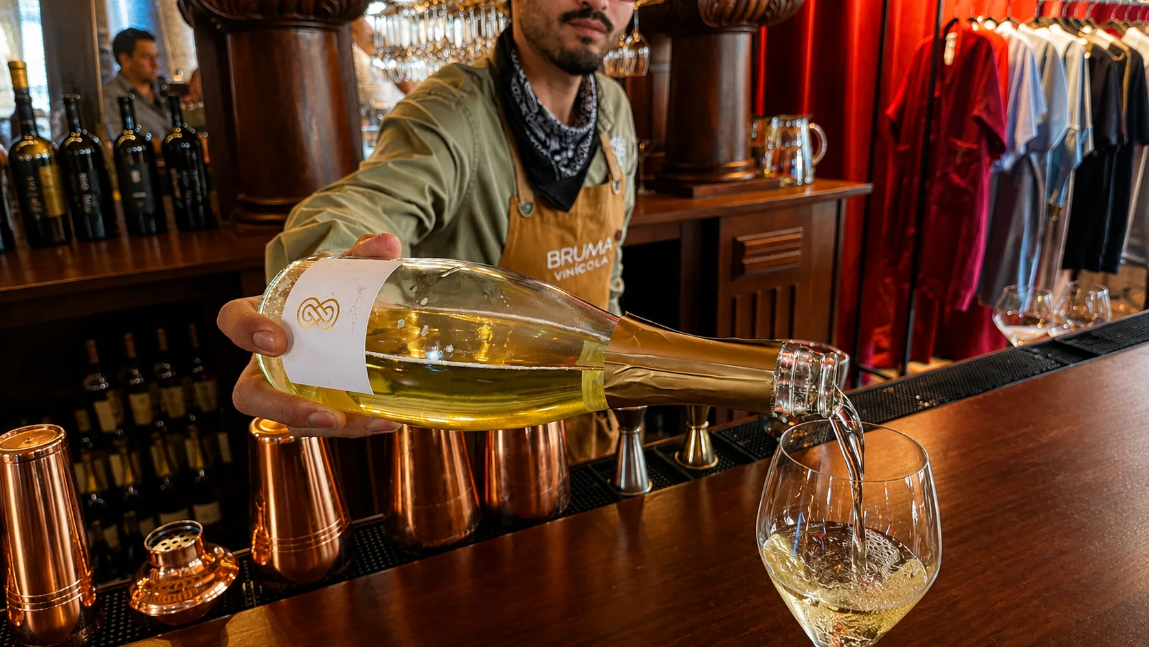 A bartender at Bruma Vinicola in Valle de Guadalupe pours white wine into a stemmed glass during a hosted tasting.